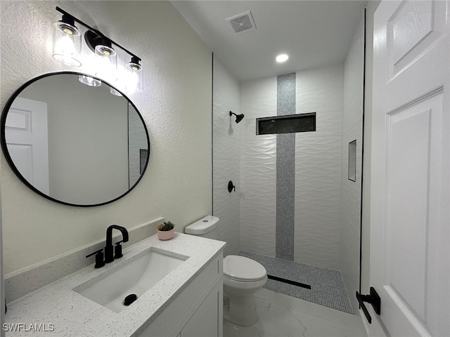 full bath with toilet, vanity, visible vents, marble finish floor, and tiled shower