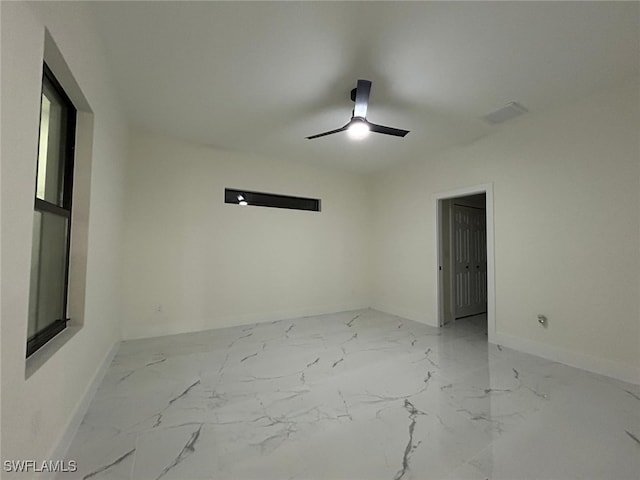 empty room with marble finish floor, ceiling fan, and baseboards