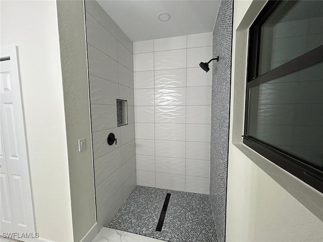 full bathroom featuring marble finish floor and a stall shower