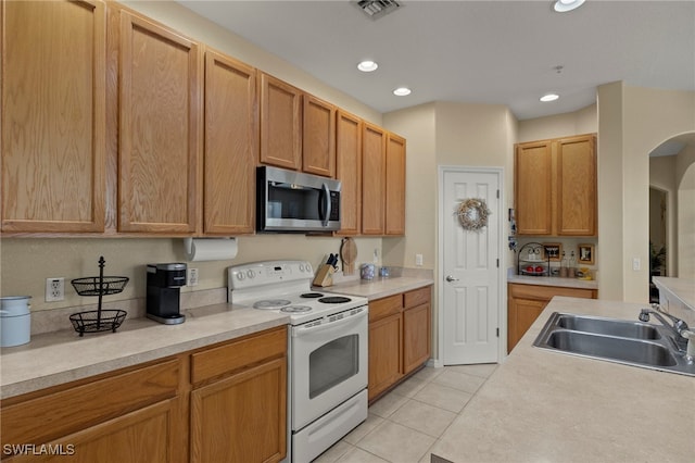 kitchen with sink, white electric range oven, and light tile patterned floors