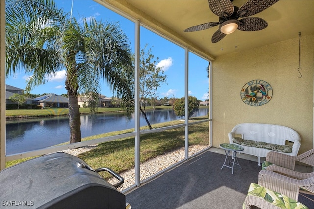 sunroom with a water view and ceiling fan