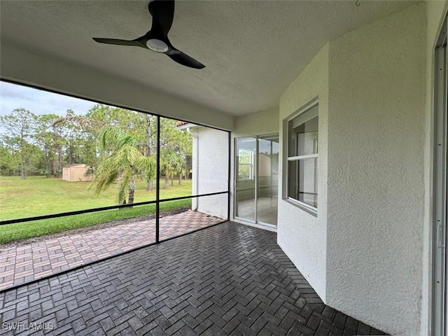 unfurnished sunroom featuring ceiling fan