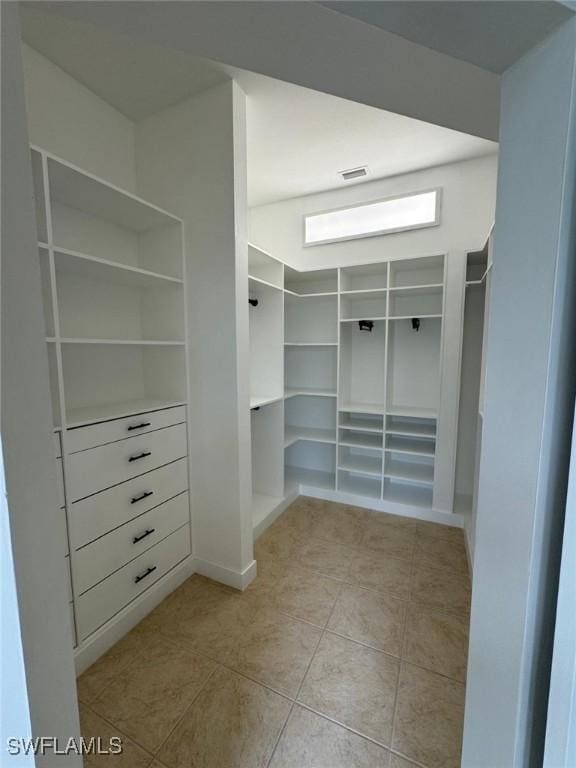 walk in closet with light tile patterned floors