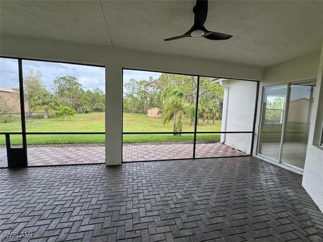 unfurnished sunroom featuring ceiling fan