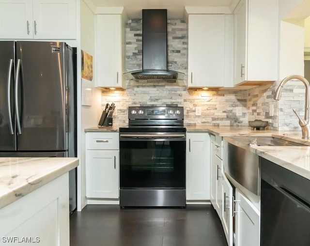 kitchen featuring light stone countertops, white cabinets, appliances with stainless steel finishes, wall chimney range hood, and backsplash