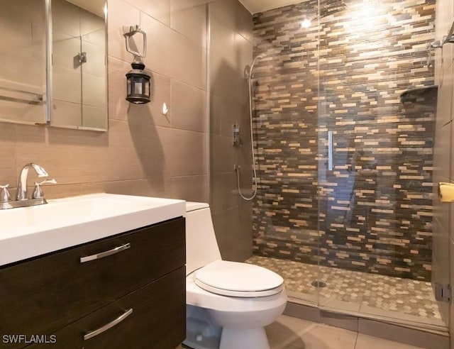 bathroom with vanity, a shower with shower door, tile patterned floors, and toilet