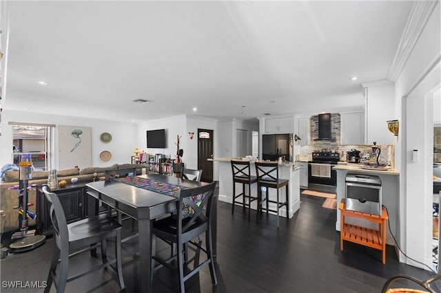 dining room featuring crown molding and dark hardwood / wood-style flooring