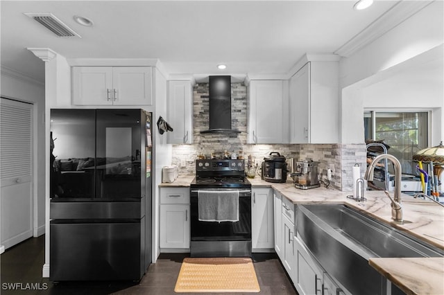 kitchen featuring white cabinets, black refrigerator, electric range, and wall chimney exhaust hood