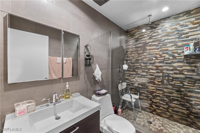 bathroom with toilet, a shower with shower door, tile walls, vanity, and backsplash