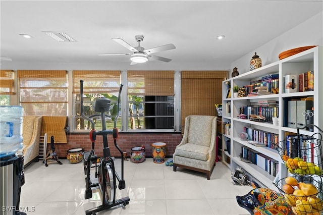 interior space with brick wall, light tile patterned floors, and ceiling fan