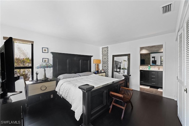 bedroom featuring dark wood-type flooring and connected bathroom