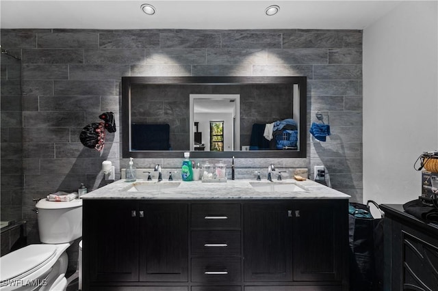 bathroom featuring decorative backsplash, vanity, toilet, and tile walls