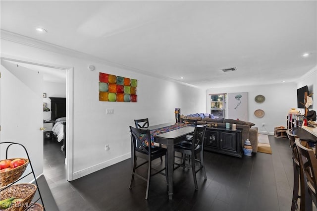 dining space with ornamental molding and dark hardwood / wood-style floors