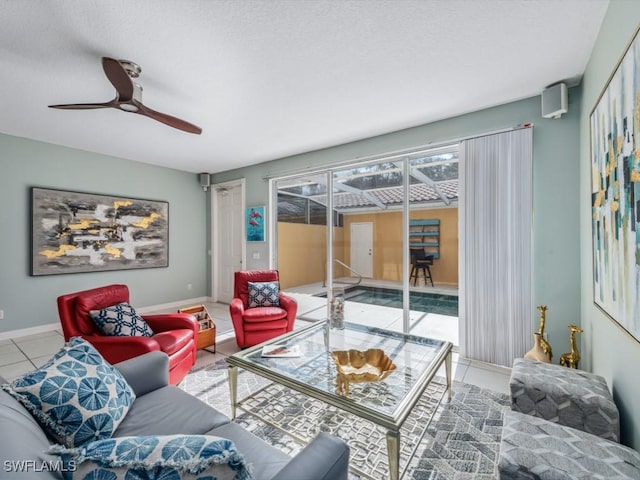 tiled living room featuring ceiling fan and baseboards