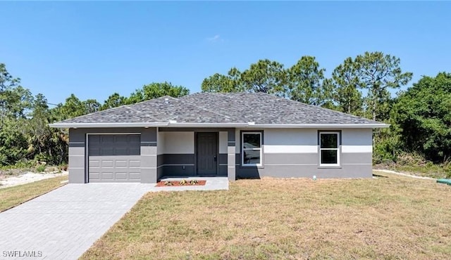 single story home with a garage and a front lawn