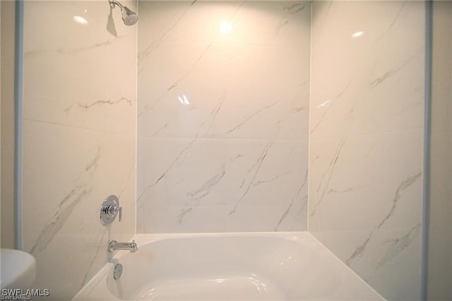 bathroom with toilet and tiled shower / bath combo