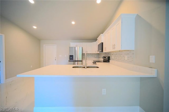 kitchen with kitchen peninsula, sink, white cabinetry, and appliances with stainless steel finishes