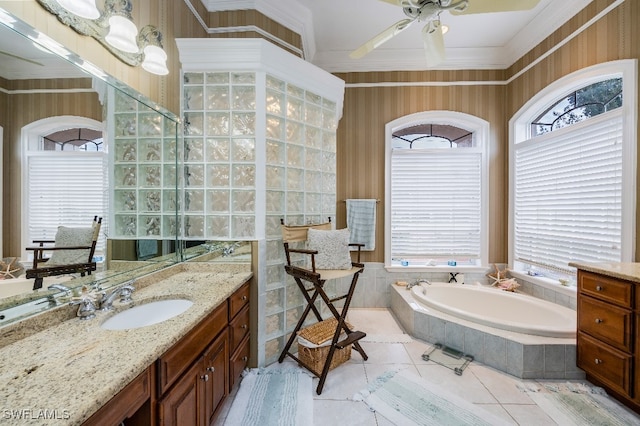 bathroom with tile patterned flooring, tiled tub, vanity, ornamental molding, and ceiling fan