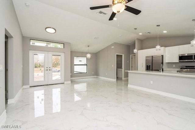 kitchen with pendant lighting, appliances with stainless steel finishes, white cabinetry, french doors, and sink