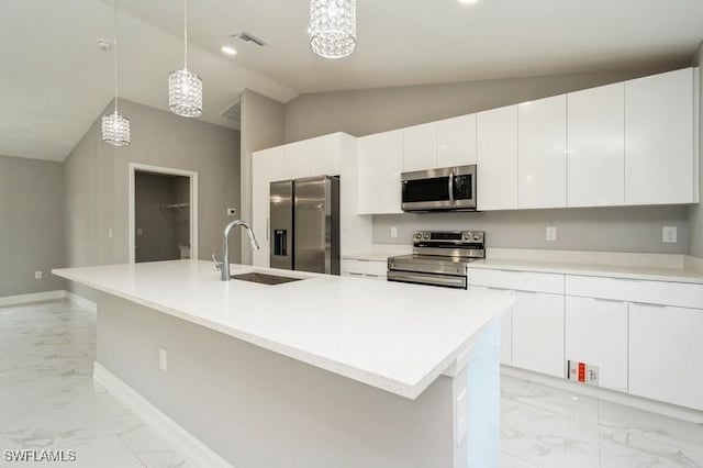 kitchen with a kitchen island with sink, appliances with stainless steel finishes, white cabinetry, and pendant lighting