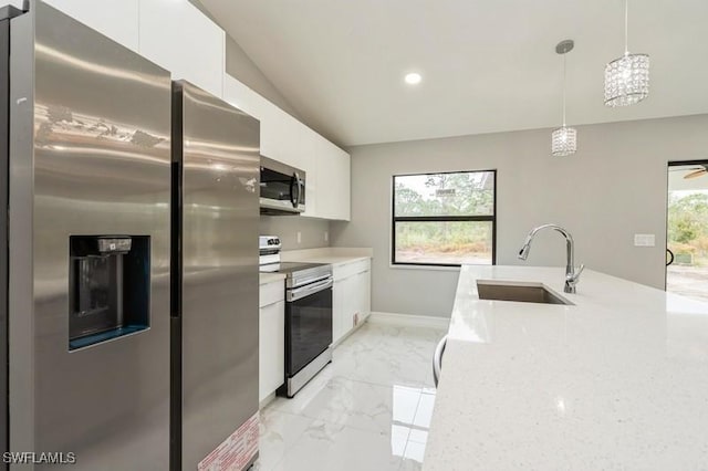 kitchen with white cabinetry, appliances with stainless steel finishes, light stone countertops, pendant lighting, and sink