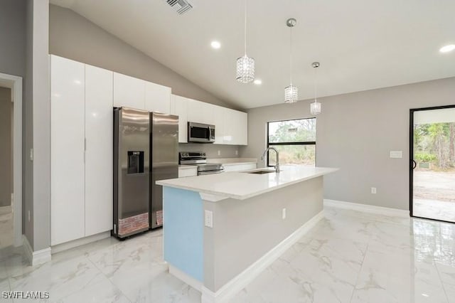 kitchen featuring white cabinetry, appliances with stainless steel finishes, a kitchen island with sink, vaulted ceiling, and pendant lighting