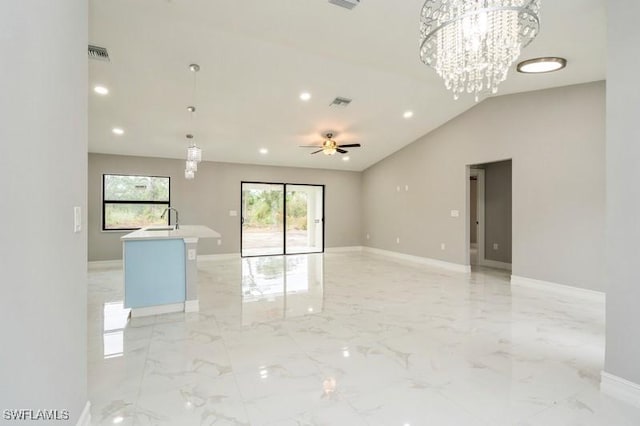 spare room with vaulted ceiling, ceiling fan with notable chandelier, and sink