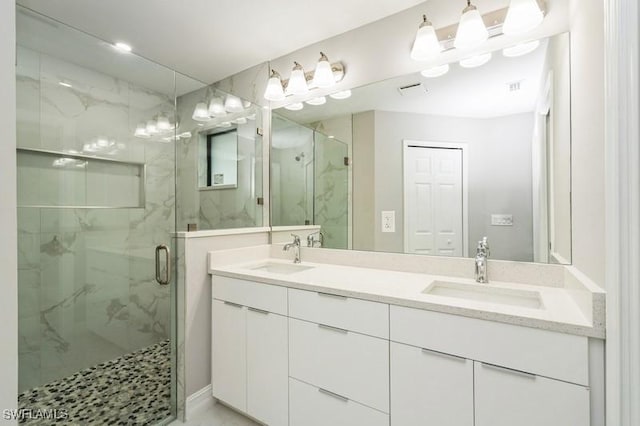 bathroom featuring a shower with shower door and vanity