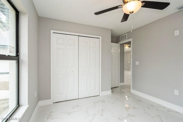 unfurnished bedroom with ceiling fan and a closet