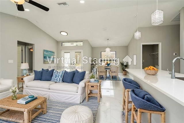 living room with ceiling fan, vaulted ceiling, and sink