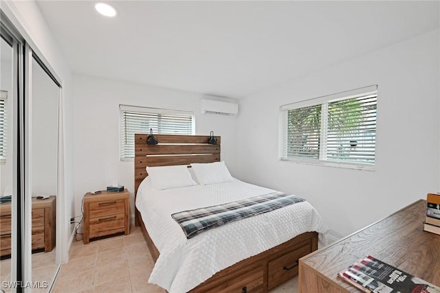 bedroom featuring light tile patterned flooring, a wall mounted AC, and a closet