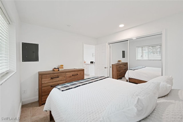 tiled bedroom with electric panel and a closet