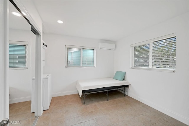 bedroom with multiple windows, a wall mounted air conditioner, and a closet