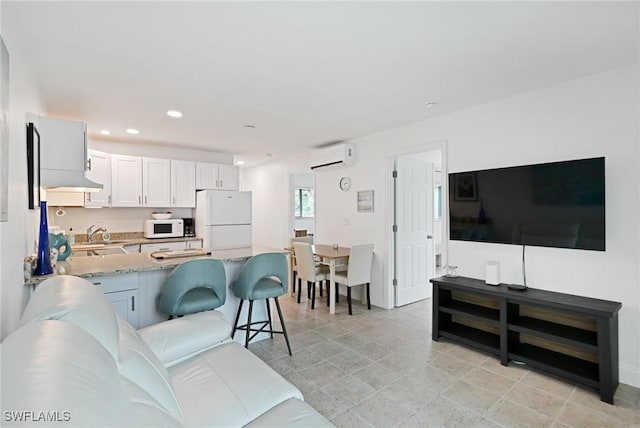 living room featuring an AC wall unit and sink