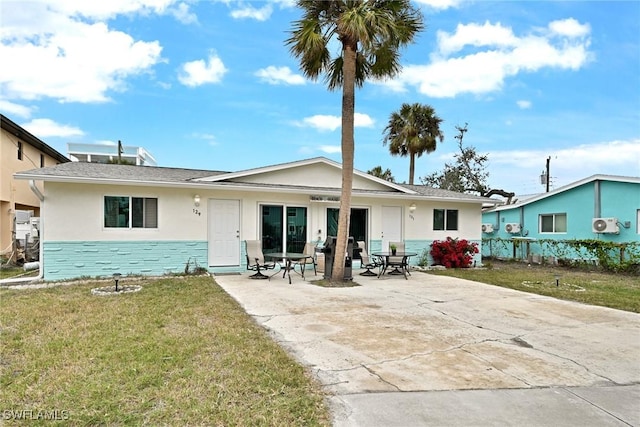 rear view of house featuring a lawn and a patio