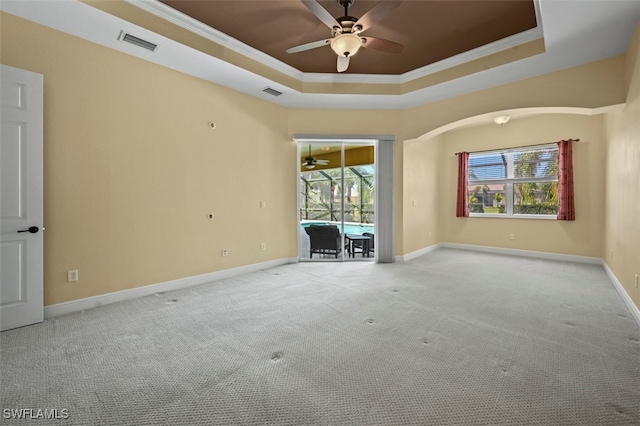 13230 Lazzaro Ct, Estero, FL 33928 - empty room with ceiling fan, a tray ceiling, carpet flooring, plenty of natural light, and crown molding