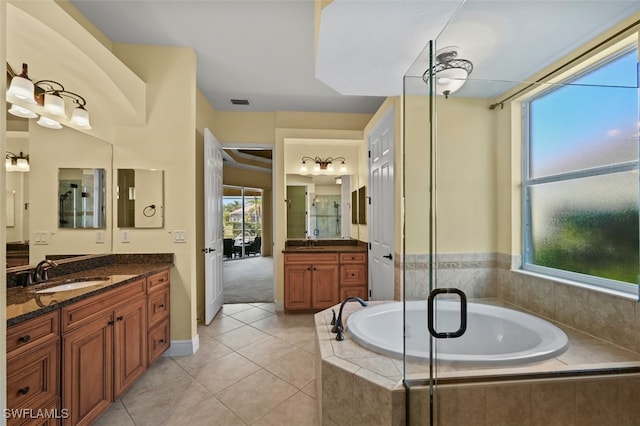 bathroom featuring tile patterned floors, vanity, and tiled tub