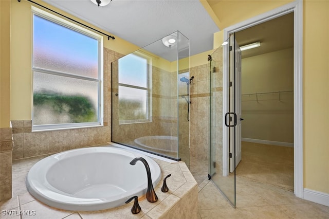 bathroom with independent shower and bath, plenty of natural light, and tile patterned floors