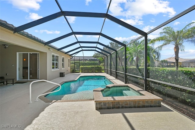 view of swimming pool with an in ground hot tub, a patio, and glass enclosure