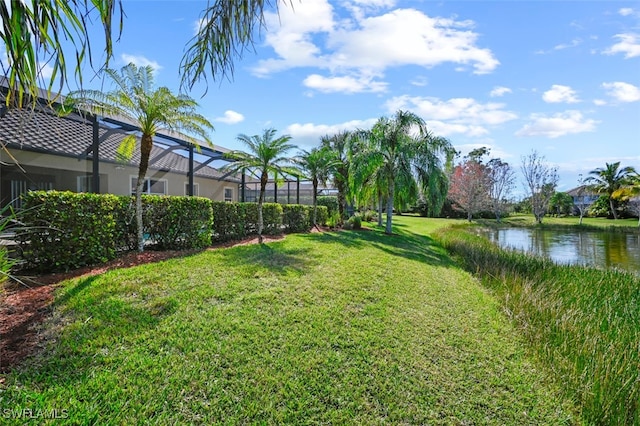 view of yard featuring a water view and glass enclosure