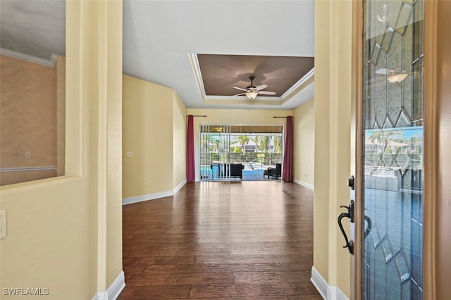 foyer with hardwood / wood-style flooring, ceiling fan, ornamental molding, and a tray ceiling