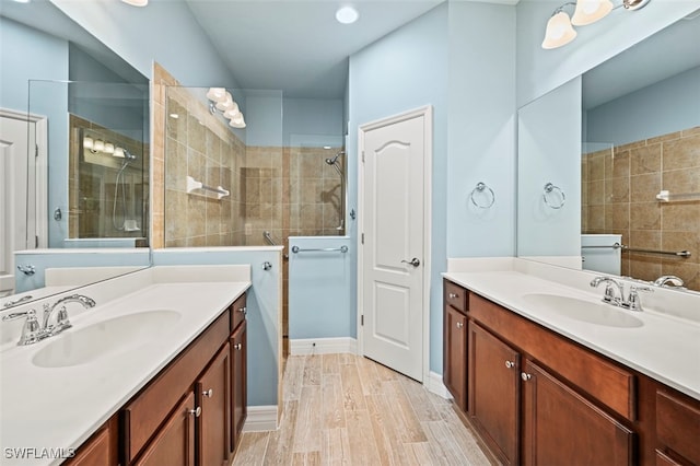 bathroom with vanity, tiled shower, and hardwood / wood-style floors