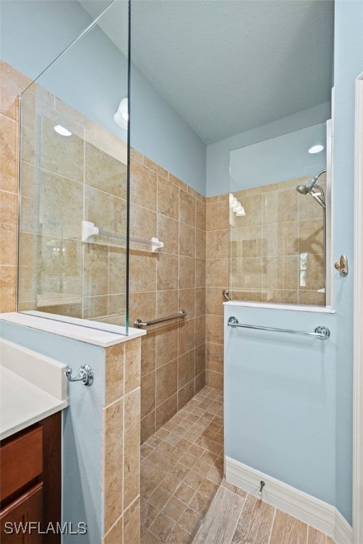 bathroom with vanity and tiled shower