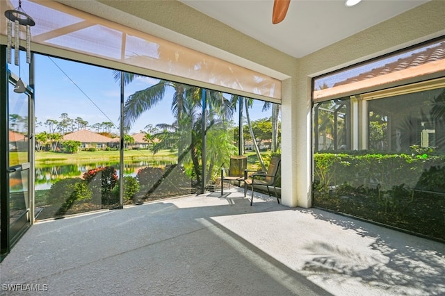 unfurnished sunroom with a water view and ceiling fan