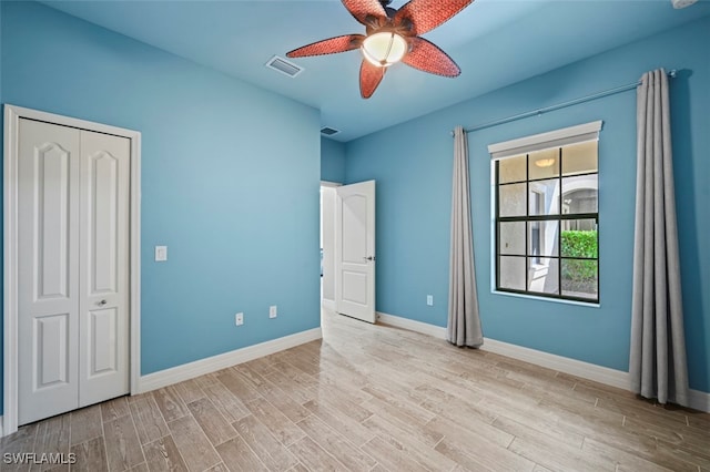 unfurnished bedroom with ceiling fan and light wood-type flooring