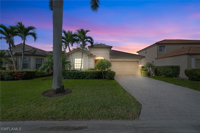 view of front of property featuring a garage and a lawn