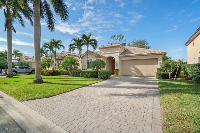 mediterranean / spanish-style house with a garage and a front lawn