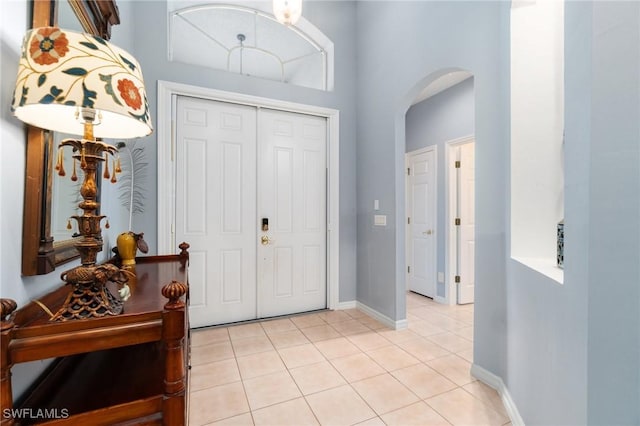 tiled foyer featuring a towering ceiling