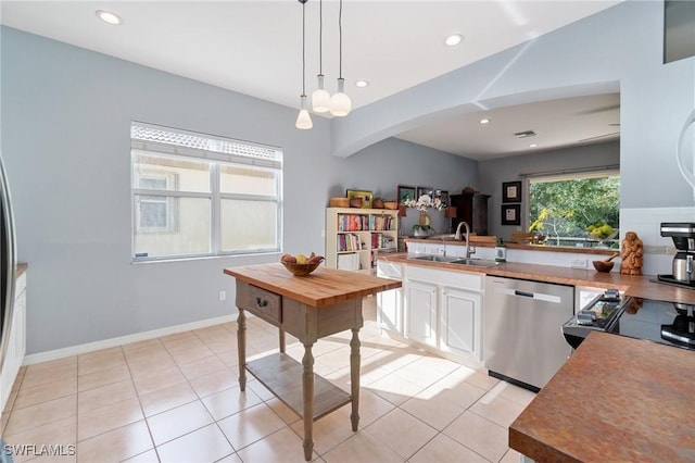 kitchen with sink, decorative light fixtures, light tile patterned floors, dishwasher, and white cabinets