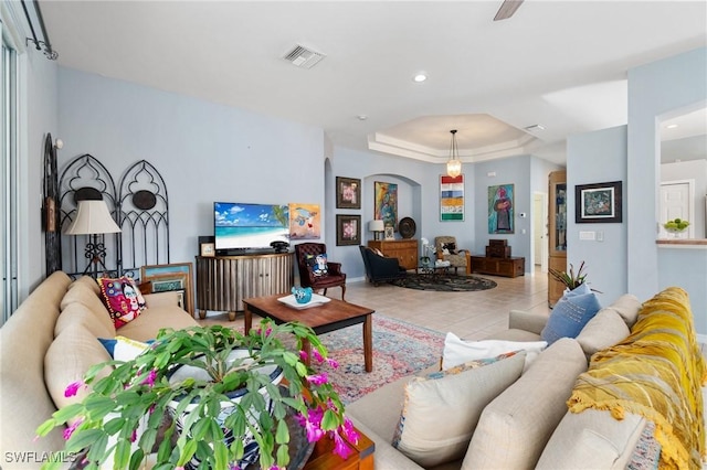 tiled living room featuring a raised ceiling